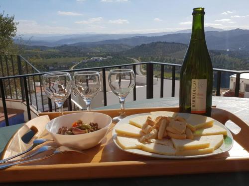 einen Tisch mit einer Flasche Wein und einem Teller Essen in der Unterkunft Mirador del Olivar in Olvera