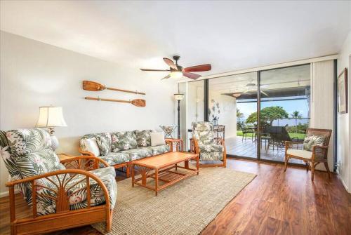 a living room with a couch and chairs and a ceiling fan at Beautiful 2/2 condo in Kailua Kona. Ocean View! in Kailua-Kona