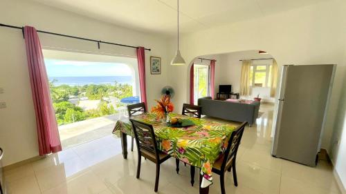 a dining room with a table and a view of the ocean at The Songbird Villa in Pointe Au Sel 