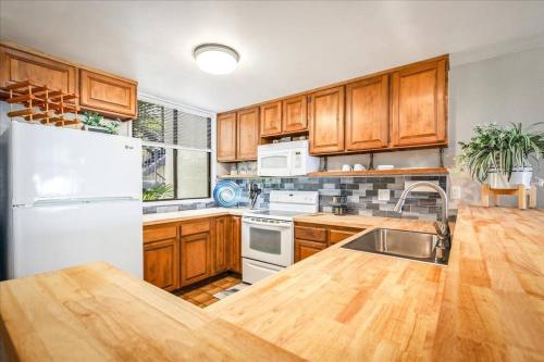 a kitchen with wooden cabinets and a white refrigerator at Beautiful 2/2 condo in Kailua Kona. Ocean View! in Kailua-Kona