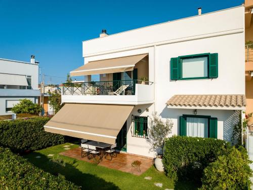 a white house with a large awning at Rio Beach Residence in Patra