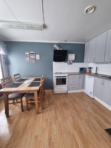 a kitchen with a wooden table and a dining room at Storgalten gjestehus in Nord-Lenangen