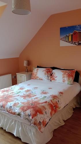 a bedroom with a bed with a floral bedspread at Bundoran Guesthouse in Bundoran