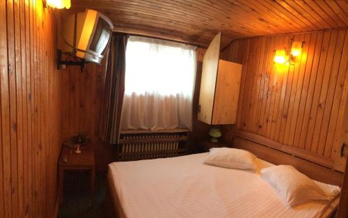 a bedroom with a large bed with a window at Hotel Bucegi Portile Regatului in Paraul Rece