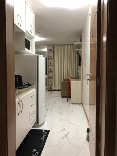 eine Küche mit weißen Schränken und einem Kühlschrank in der Unterkunft Life Resort - Brasília in Brasilia