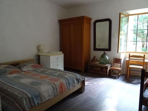 une chambre avec un lit, une commode et un miroir dans l'établissement Maison au cœur de la Drôme, à Rochebaudin