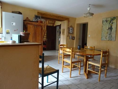 une cuisine et une salle à manger avec une table et des chaises dans l'établissement Maison au cœur de la Drôme, à Rochebaudin