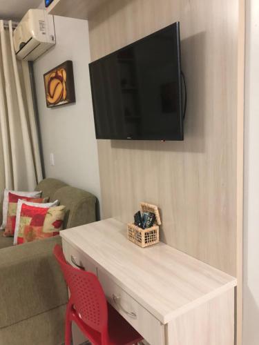 ein Wohnzimmer mit einem Fernseher an der Wand in der Unterkunft Life Resort - Brasília in Brasilia