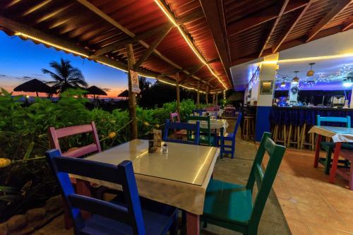 Las Lajas Beach Resort في لاس لاخاس: مطعم بطاولة وكراسي وبار