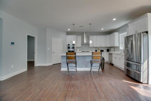 a kitchen with white cabinets and a kitchen island with chairs at Dumfries Vacation Rental about 32 Mi to Washington DC! in Dumfries
