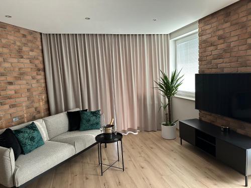 a living room with a couch and a flat screen tv at Premium Apartament Polna Szczecinek in Szczecinek