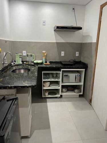 a kitchen with a sink and a counter top at Studios Aromas do Campeche - Floripa in Florianópolis