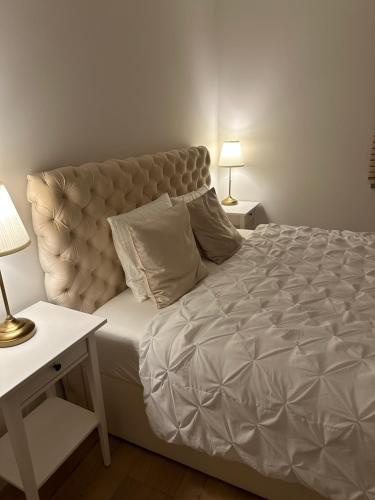 Premium Apartament Polna Szczecinek في شتيتشينيك: غرفة نوم بسرير كبير مع طاولتين ومصباحين