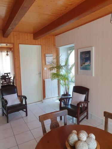un salon avec deux chaises et une table dans l'établissement Gîte Au café des marguerites, à Plounévez-Lochrist