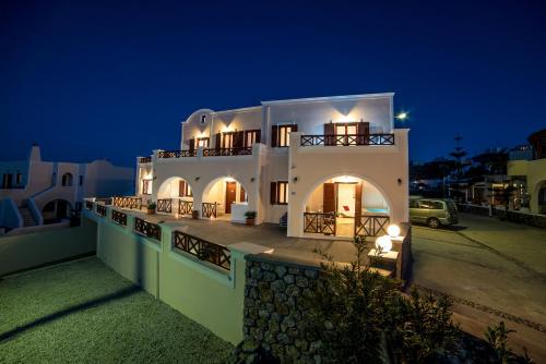 a large white house at night with a parking lot at William's Houses in Akrotiri