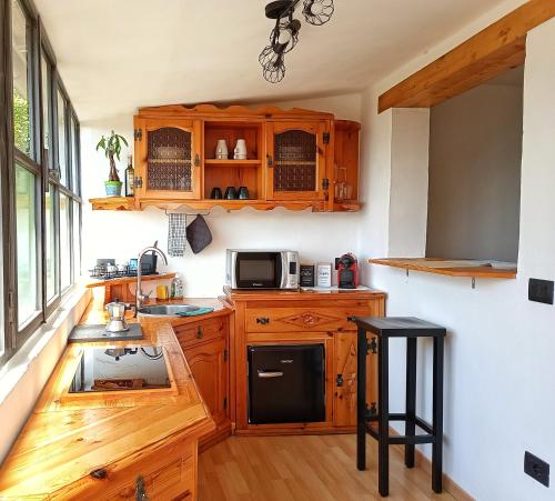 a kitchen with wooden cabinets and a black refrigerator at Ca' di Aroha in Musignano