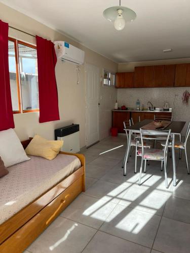 a bedroom with a bed and a table and a kitchen at Casa moderna en zona tranquila in Malargüe