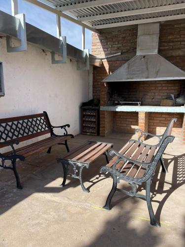 um pátio com 2 bancos e comodidades para churrascos ao ar livre em Casa moderna en zona tranquila em Malargüe