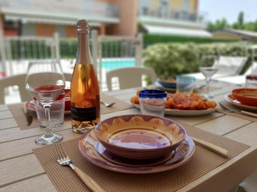 ein Tisch mit einem Teller Essen und einer Flasche Wein in der Unterkunft Nuova casa al lago con piscina in Desenzano del Garda