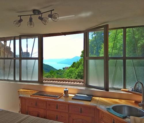 a kitchen with windows with a view of the water at Ca' di Aroha in Musignano