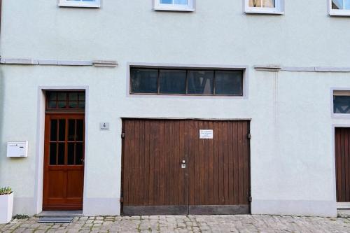 two garage doors on a white building with windows at Mitten in den Weinbergen in Sommerhausen