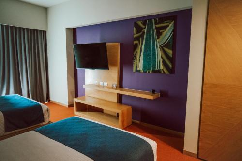 a hotel room with two beds and a tv at Gran Hotel Concordia in Irapuato