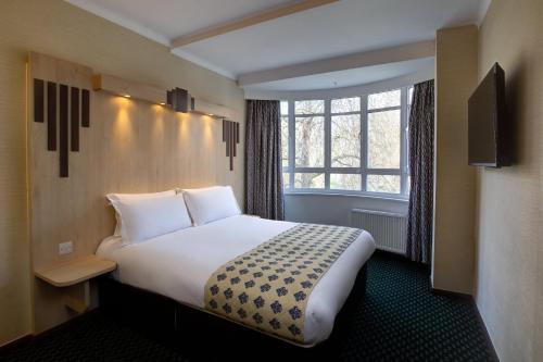 a hotel room with a large bed and a window at Tavistock Hotel in London