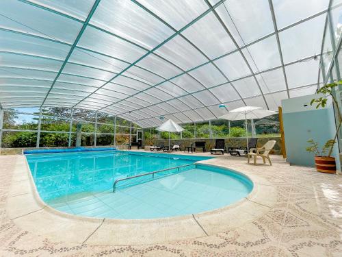 a large swimming pool with a glass roof at HOTEL PANORAMA SOL in Chachagüí