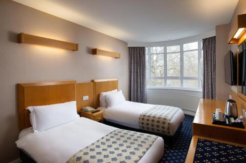 a hotel room with two beds and a window at Tavistock Hotel in London