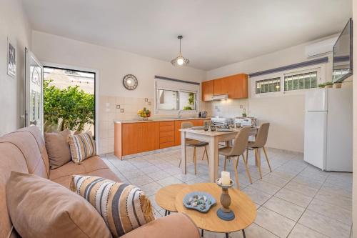 ein Wohnzimmer und eine Küche mit einem Sofa und einem Tisch in der Unterkunft Panormos Luxury House in Rhodos (Stadt)