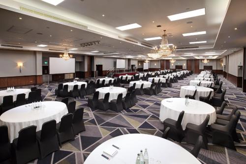 a banquet hall with white tables and black chairs at Royal National Hotel in London