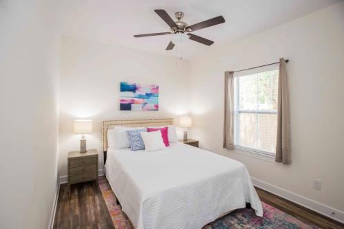 Un dormitorio blanco con una cama y un ventilador de techo. en Chic Thomasville Home Walk to Downtown!, en Thomasville