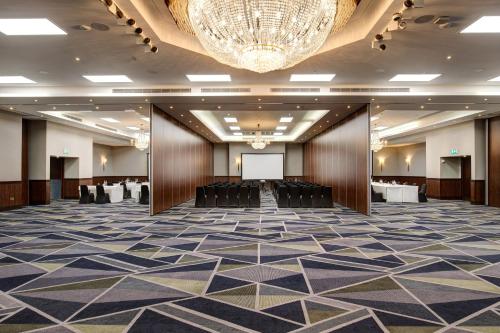 a large room with a chandelier and a hall with chairs at Royal National Hotel in London