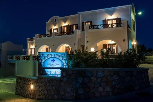 a large white house at night with lights at William's Houses in Akrotiri