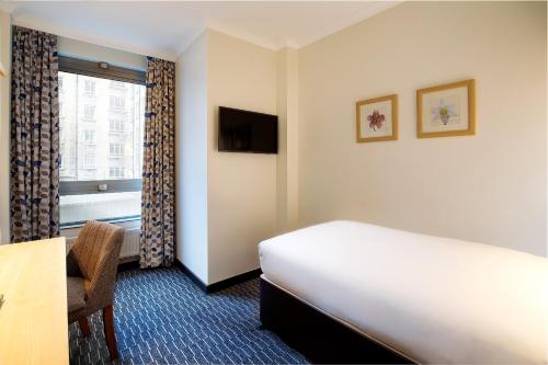 Habitación de hotel con cama y ventana en Royal National Hotel, en Londres