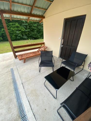 a patio with chairs and a bench in front of a building at Iskra DDUR in Gornji Milanovac