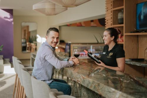 un hombre y una mujer sentados en un bar con una copa de vino en Gran Hotel Concordia en Irapuato