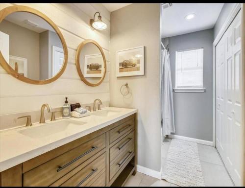 a bathroom with a sink and two mirrors at Beachfront Envy in Galveston