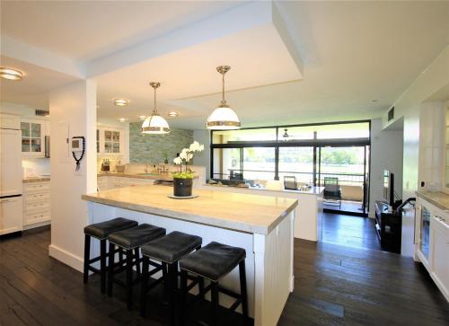 a kitchen with a large island with black stools at Kaanapali Royal Golf Retreat in Lahaina