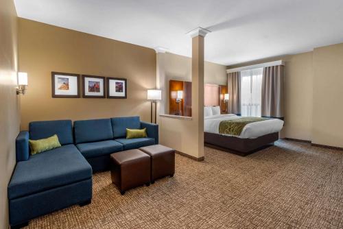 a hotel room with a couch and a bed at Comfort Suites Denver near Anschutz Medical Campus in Aurora