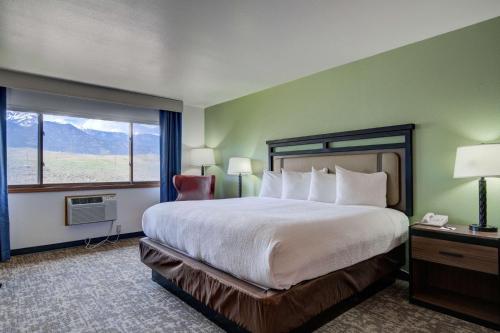 a hotel room with a large bed and a window at The Ridgeline Hotel at Yellowstone, Ascend Hotel Collection in Gardiner