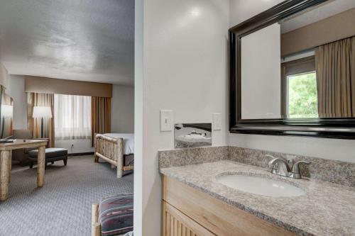 a bathroom with a sink and a room with a bedroom at The Ridgeline Hotel at Yellowstone, Ascend Hotel Collection in Gardiner