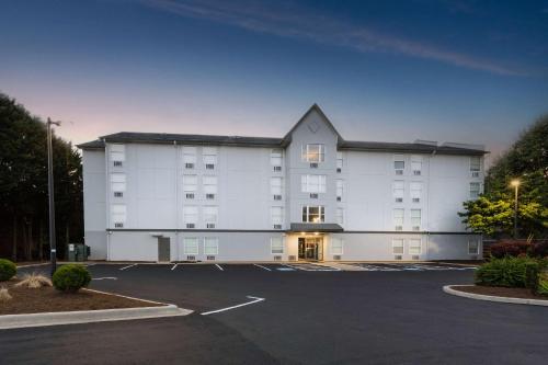 a large white building with a parking lot at Rodeway Inn & Suites near Outlet Mall - Asheville in Asheville
