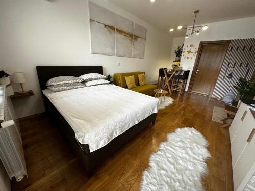 ein Schlafzimmer mit einem Bett und ein Wohnzimmer in der Unterkunft Apartman Katarina in Palić