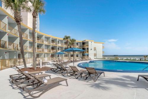 uma piscina com espreguiçadeiras e um resort em Chateau Beachfront Resort - BW Signature Collection em Panama City Beach