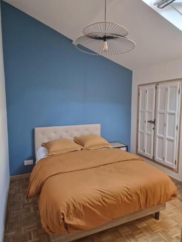 um quarto com uma cama com uma parede azul em LE RIO em Givry
