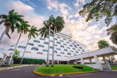 a hotel with palm trees in front of it at Crowne Plaza Managua by IHG in Managua