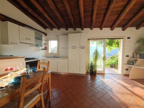 a kitchen with white cabinets and a table with chairs at Island Sunset House in Sulzano