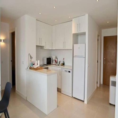 a kitchen with white cabinets and a white refrigerator at Felmin in Portals Nous