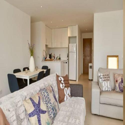a living room with a couch and a table and a kitchen at Felmin in Portals Nous